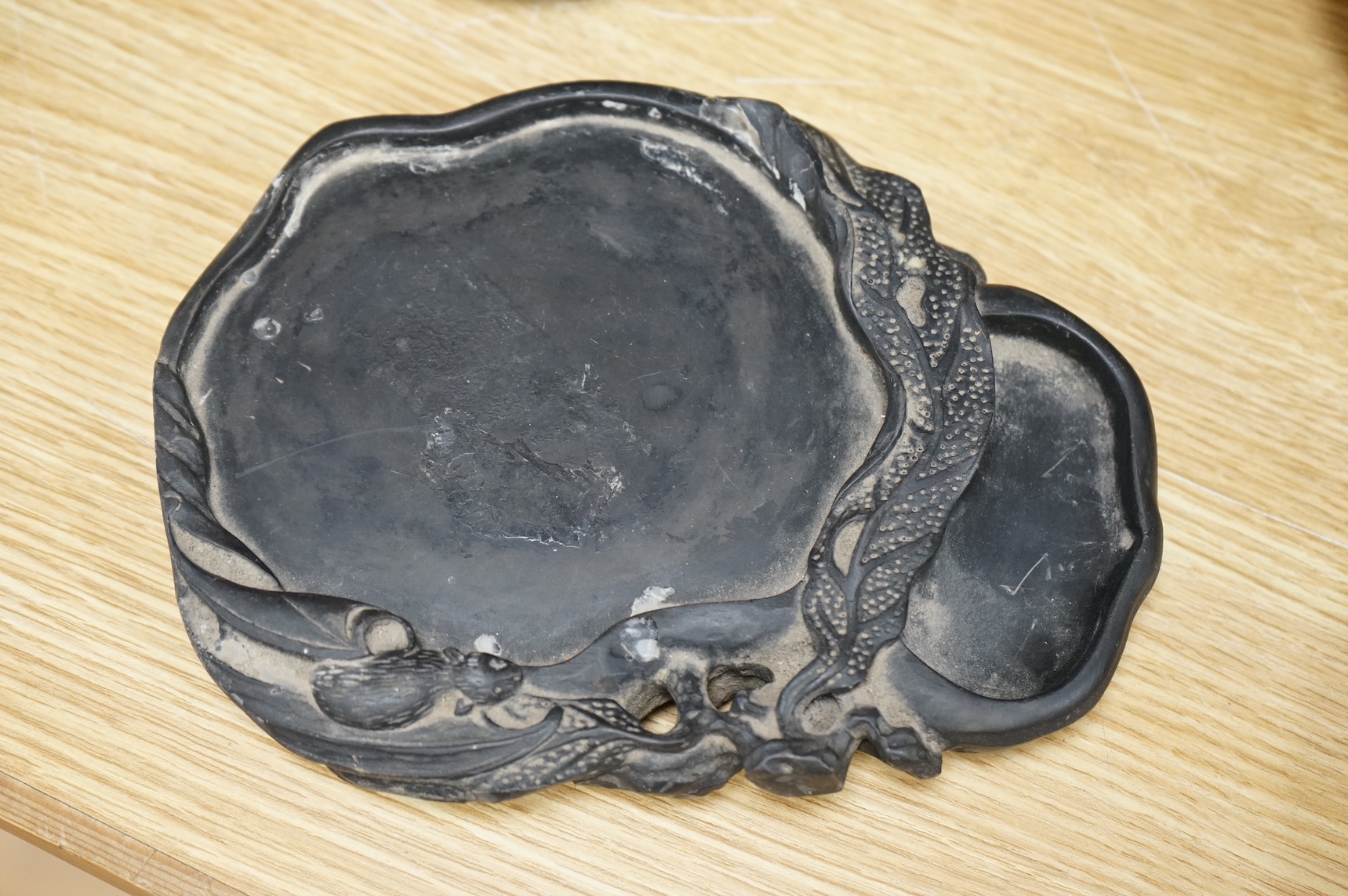 A Chinese carved inkstone, character marks to the base, 23cm